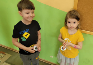 Dziewczynka i chłopiec pokazują emblematy z takimi samymi kolorami książek