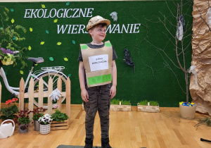 Chłopiec stoi na scenie i recytuje wiersz „Na leśnej polanie”.