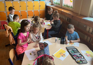 Dzieci wykonują opaskę na głowę z pszczółką.