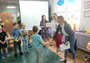 Pani Sylwia gratuluje chłopcu z grupy Smerfy a Pani Dyrektor wręcza mu dyplom za udział w turnieju.