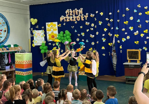 Dzieci przebrane za pszczoły na przedszkolnej scenie.