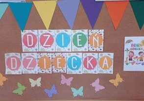 Zdjęcie przedstawia napis: Dzień Dziecka, na górze dekorację stanowi proporczyk a pod napisem zostały przypięte kolorowe motylki. Po prawej stronie znajduje się kartka z ilustracją przedstawiającą dzieci.