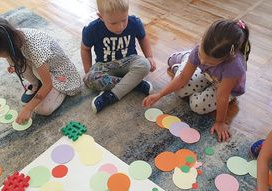 Dzieci z grupy Słoneczka układają z małych i dużych kółek dowolne wzory.