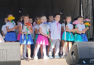 Dzieci z grupy Smerfy stoją na scenie, śpiewają piosenkę konkursową.