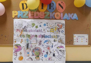 na tablicy z pracami dzieci wisi ogromna, wspólnie pokolorowana kolorowanka z okazji dnia przedszkolaka