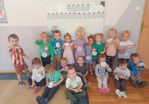 Dzieci z grupy Biedronki pozują do zdjęcia na tle napisu Dzień Przedszkolaka.