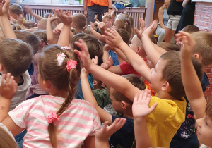 Dzieci podczas koncertu zgłaszają się do wykonania muzycznego zadania.
