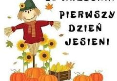 Na zdjęciu widnieje napis 23 wrzesień Pierwszy Dzień Jesieni. Widać postać ze słomy, dynie, słoneczniki oraz skrzynkę z kukurydzą.