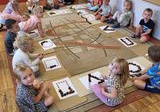 Dzieci z grupy Stokrotki układają wzory z wykorzystaniem kasztanów.