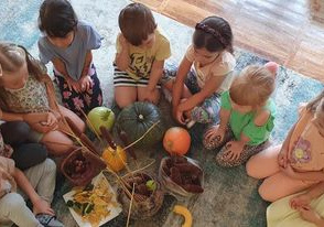 Dzieci z grupy Słoneczka przyglądają się przyniesionym darom jesieni.