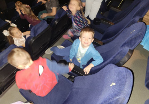 Chłopiec uśmiechnięty przed seansem filmowym.