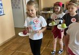 Dzieci z grupy Odkrywcy bawią się w kelnerów- noszą jabłuszka na papierowych tackach.