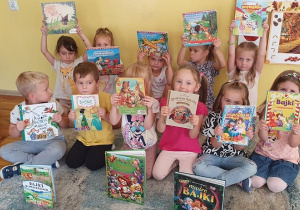 Dzieci z grupy Słoneczka pokazują książki z bajkami.