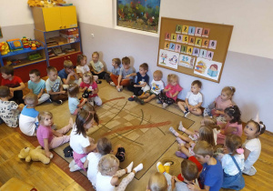 Dzieci z grupy Pszczółki wiedza z przedszkolakami z grupy Stokrotki i słuchają bajki.
