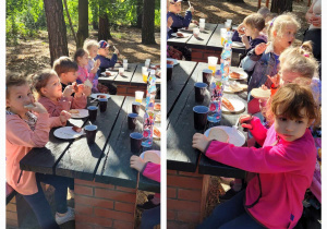 Dzieci siedzą przy stolikach i jedzą kiełbaski z grilla.