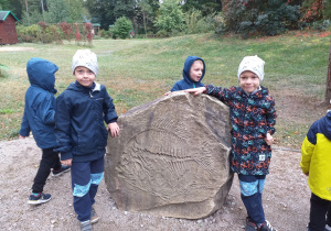Dzieci z grupy Tropiciele przy skamielinie.