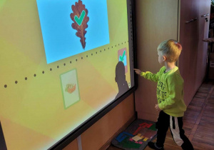 Chłopiec rozwiązuje zagadkę przy tablicy interaktywnej.