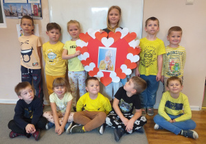 Dzieci z grupy "Tropiciele" pozują do zdjęcia z sercem dla Jana Pawła II w swojej sali.