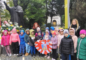 Grupa "Smerfy" z nauczycielkami pozuje do zdjęcia przy pomniku Jana Pawła II.