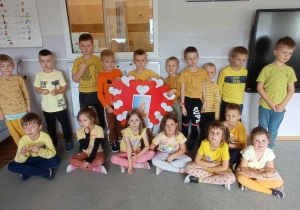 Dzieci z grupy "Pszczółki" pozują do zdjęcia z sercem dla Jana Pawła II w swojej sali.