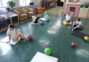 gimnastyka korekcyjna, dzieci ćwiczą stopy siedząc na macie