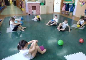 gimnastyka korekcyjna, dzieci ćwiczą z kolorowymi piłkami